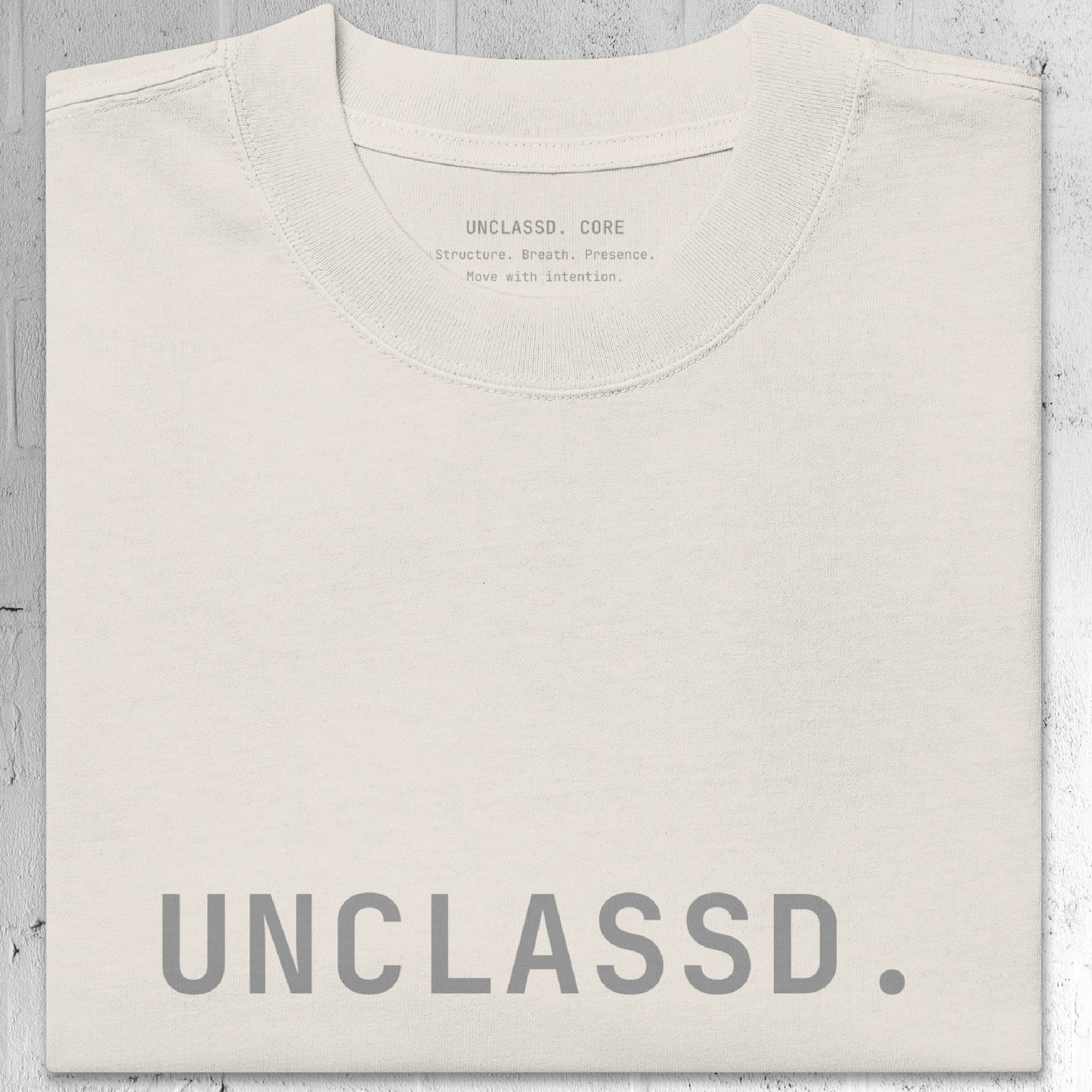 Tonal “UNCLASSD.” chest print detail on the CORE Oversized Tee in Bone color.