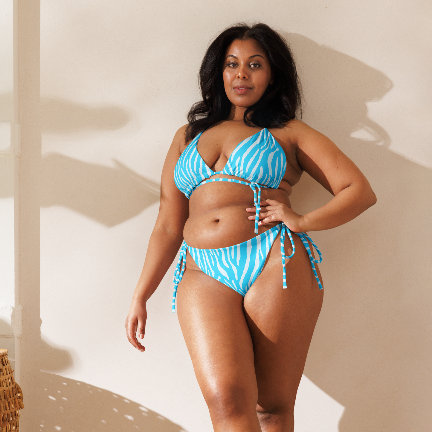 Woman wearing a neon blue zebra triangle bikini with adjustable tie straps by Unclassd.